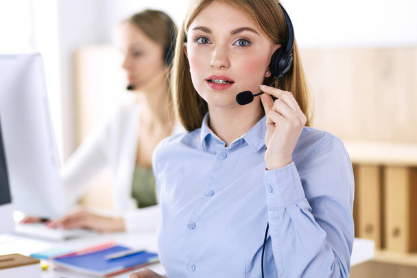 Portrait of call center operator at work. Group of people in a headset ready to help customers. Business concept - Foto, Bild
