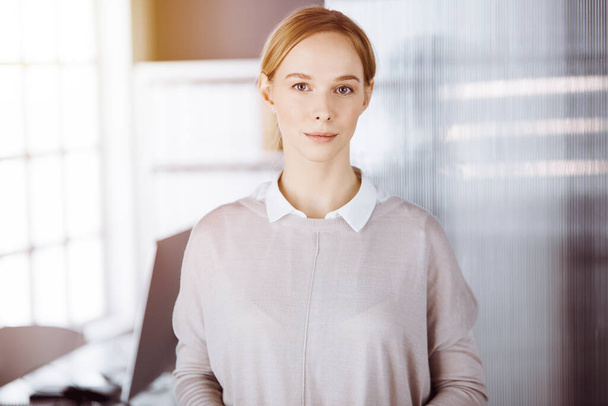 Friendly adult casual dressed business woman standing straight. Concept of a business headshot or portrait in office - Zdjęcie, obraz