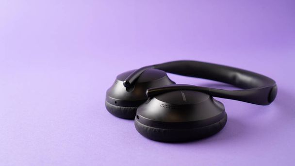 headphones with noise canceling and the best microphone. black wireless headphones on purple background. - Photo, Image