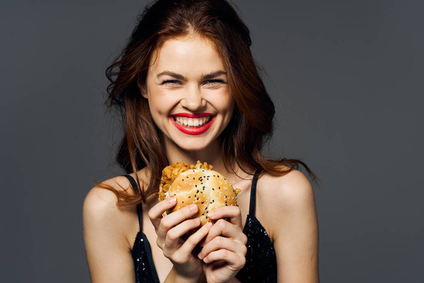 Joven mujer hermosa con hambyrger. Captura de estudio - Foto, imagen