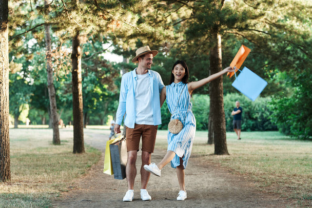young couple with shopping bags  in the park - Photo, image