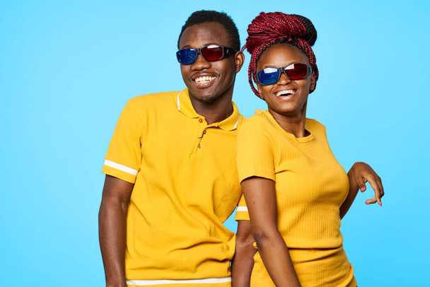 jeune beau couple portant des lunettes 3D en studio sur fond bleu - Photo, image