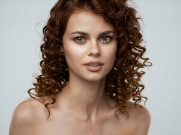 Porträt einer jungen schönen Frau mit lockigem Haar. Studioaufnahme  - Foto, Bild