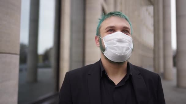 um homem com cabelo tingido fica em uma máscara na rua e sorri
 - Filmagem, Vídeo