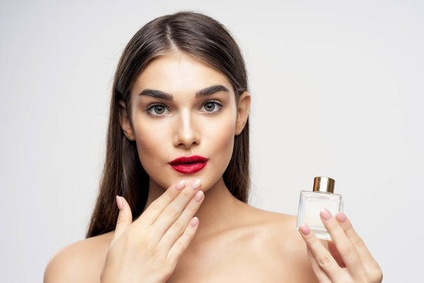 Jovem bela mulher segurando frasco de perfume no estúdio
 - Foto, Imagem