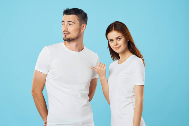 young beautiful couple in  t-shirts posing in studio on isolated background   - Photo, Image