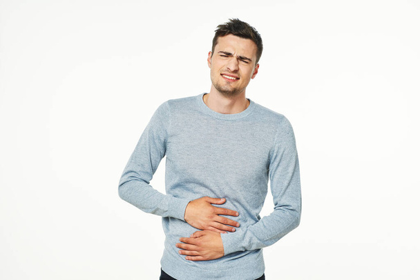 junger schöner Mann mit Bauchschmerzen isoliert auf weißem Hintergrund  - Foto, Bild