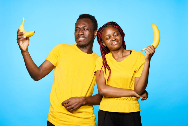 férfi és nő afrikai megjelenésű nézi banán elszigetelt háttér - Fotó, kép