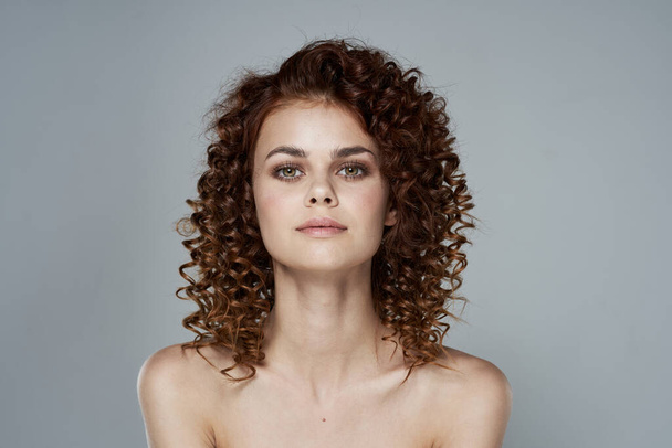 Portrait of young beautiful woman with curly hair. Studio shot - Fotó, kép