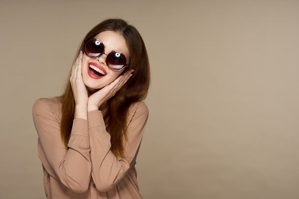 Young beautiful woman in sunglasses posing in studio  - Foto, imagen