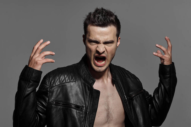 portrait of young handsome angry  man in leather jacket. Studio shot. Fashion photography   - Foto, afbeelding