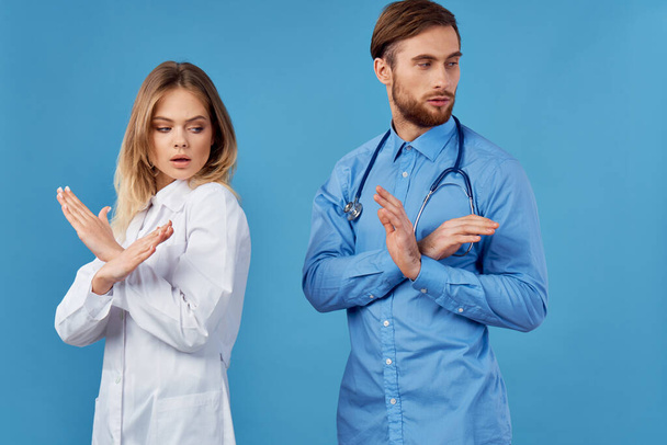 Young doctor and assistant  with stop gestures   in studio                   - Photo, Image