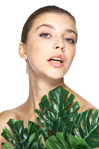 Jovem modelo bonito posando com folhas no estúdio
 - Foto, Imagem