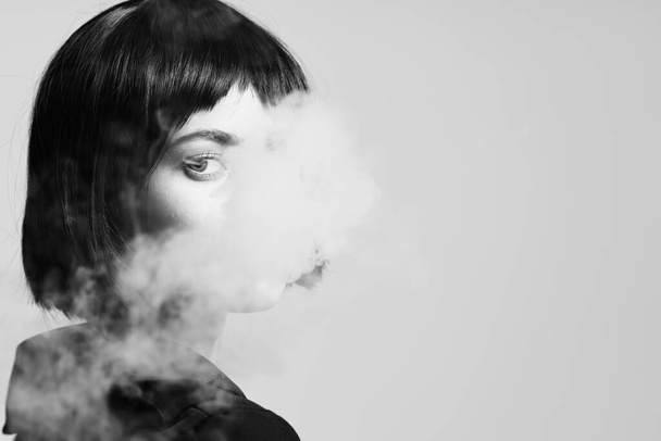 Young beautiful woman smoking in studio. Fashion photography  - Photo, image