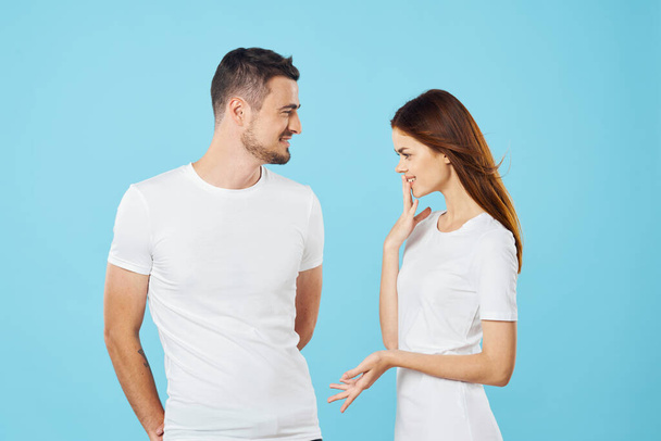 young beautiful couple in  t-shirts posing in studio on isolated background   - Photo, Image