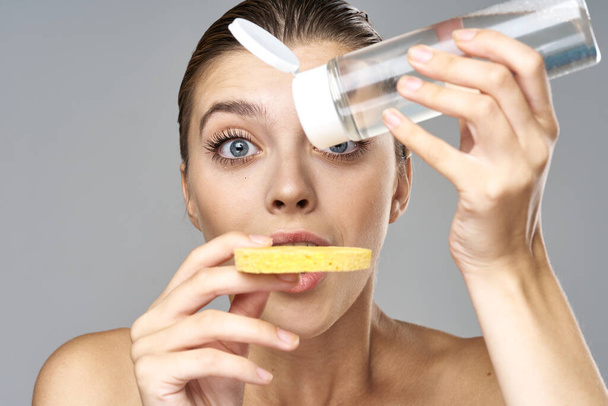 jong mooi vrouw schoonmaken haar huid met spons en micellair water  - Foto, afbeelding