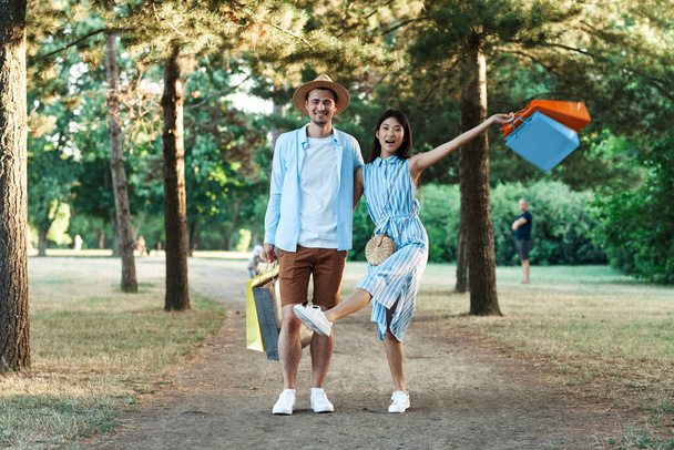 young couple with shopping bags  in the park - Photo, Image