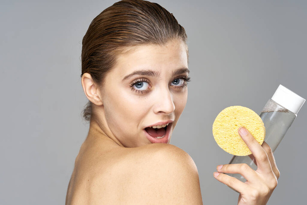 jovem mulher bonita limpando sua pele com esponja. Estúdio
 - Foto, Imagem
