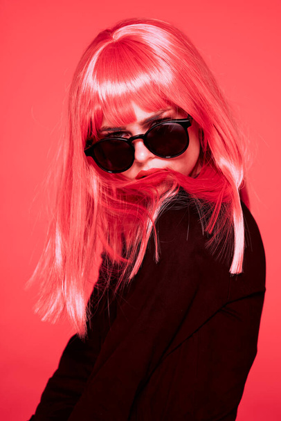 young beautiful woman in pink wig and sunglasses posing in studio  - Foto, immagini