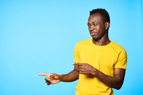 Fiatal férfi mutató el elszigetelt kék háttér - Fotó, kép