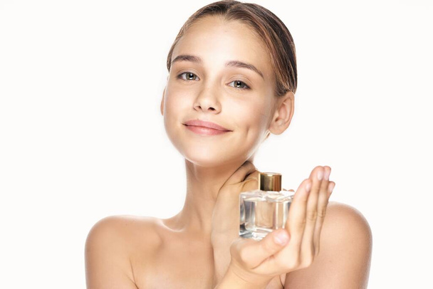 Muotokuva nuori kaunis nainen hajuvesipullo eristetty valkoisella pohjalla - Valokuva, kuva