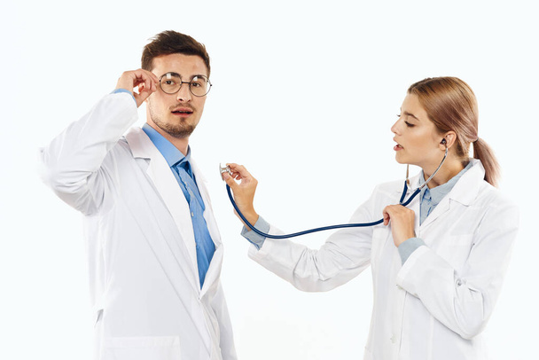 Mladí terapeuti izolovaní na bílém pozadí. žena se stetoskopem - Fotografie, Obrázek
