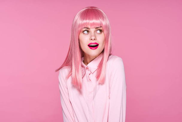 молодая красивая женщина в розовом парике позирует в студии
  - Фото, изображение