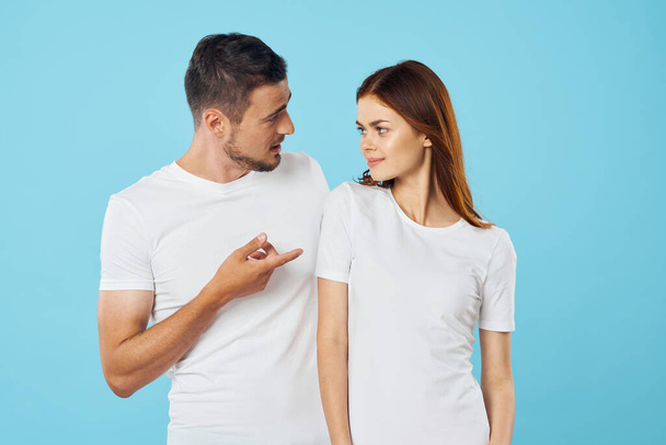 молода красива пара в футболках позує в студії на ізольованому фоні
 - Фото, зображення