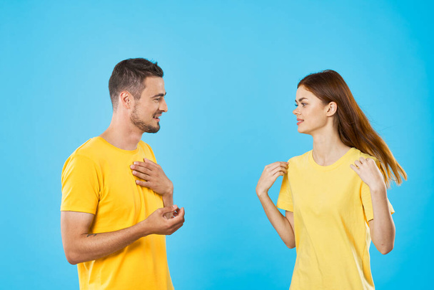 young beautiful couple in  t-shirts posing in studio on isolated background - Фото, зображення