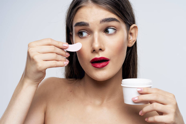 Studio shot of young beautiful woman with cream, beauty product on an isolated background - Photo, Image