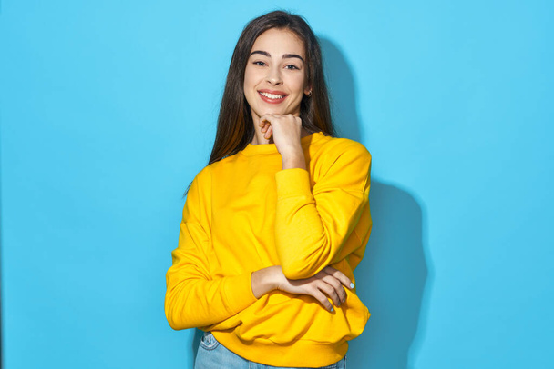 Young beautiful woman looking at camera   in studio isolated on blue background  - Photo, Image
