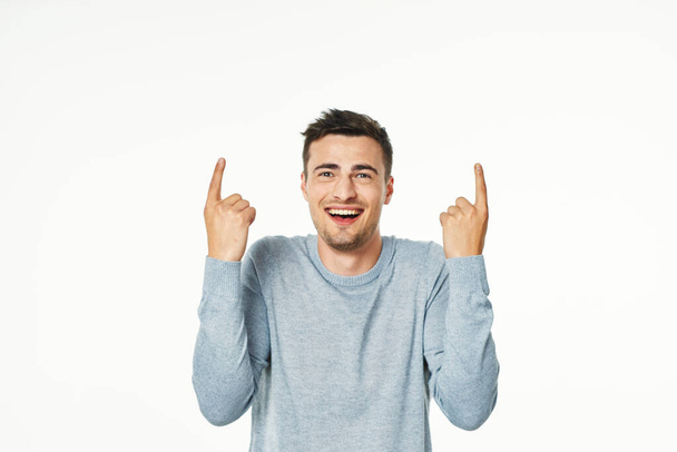 Young handsome man pointing up    in studio,  isolated background - Photo, Image