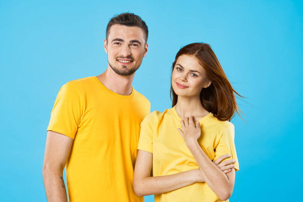 young beautiful couple in  t-shirts posing in studio on isolated background - Photo, Image