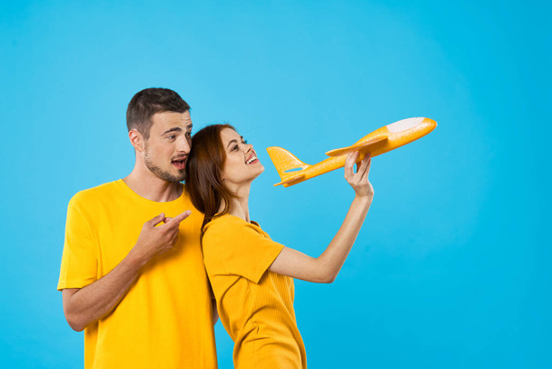jovem casal com avião de brinquedo em estúdio, fundo isolado    - Foto, Imagem