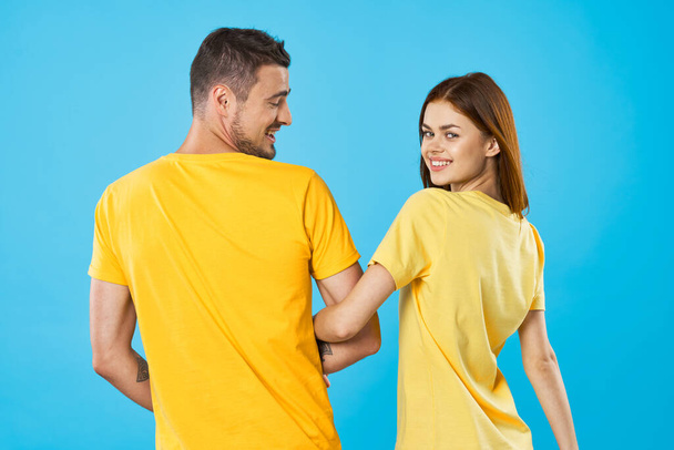 young beautiful couple in  t-shirts posing in studio on isolated background   - 写真・画像