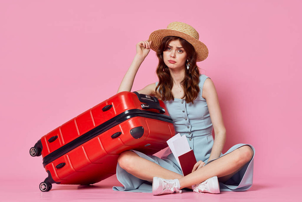 Молодая женщина с красным чемоданом в студии
 - Фото, изображение