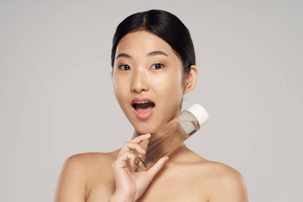 Studio shot. Portrait of young asian woman with beauty product - Foto, Bild
