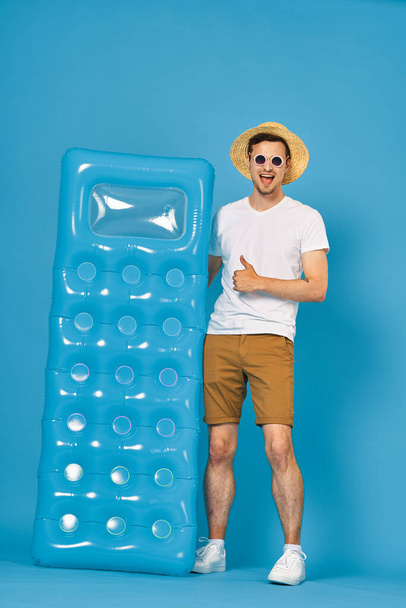 Hombre joven con colchón inflable
 - Foto, Imagen