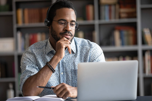 African guy wearing headset learn foreign language using internet websites - Photo, image