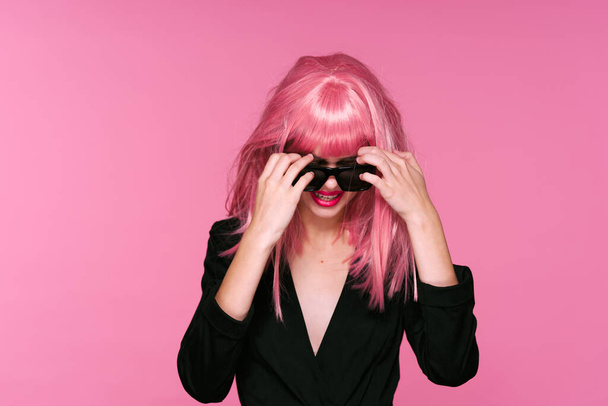 young beautiful woman in pink wig and sunglasses posing in studio  - Photo, Image
