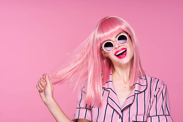 young beautiful woman in pink wig and sunglasses posing in studio  - Fotografie, Obrázek