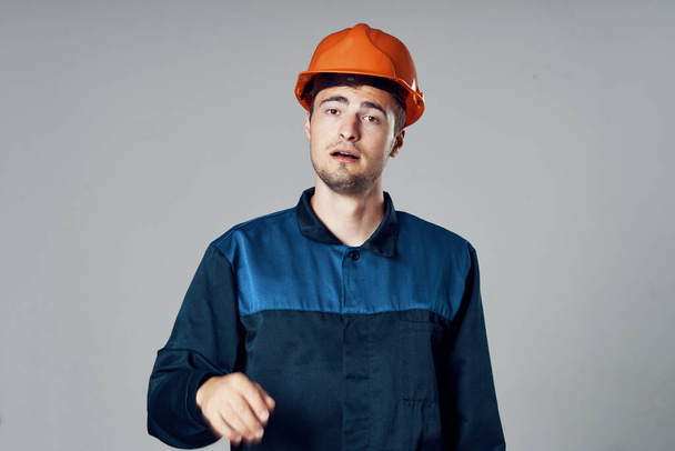 Студийный снимок Промышленный рабочий в оранжевом шлеме удивлен  - Фото, изображение