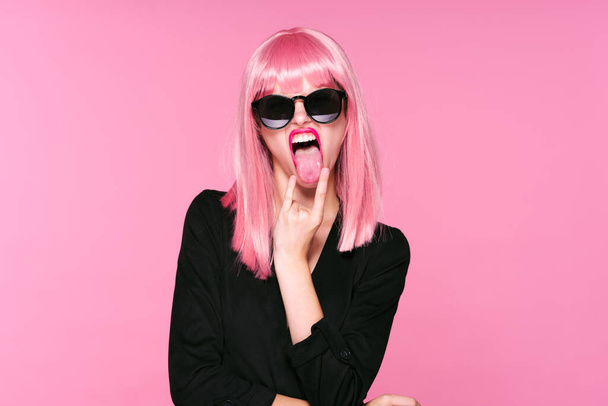 joven hermosa mujer en rosa peluca y gafas de sol posando en estudio
  - Foto, imagen