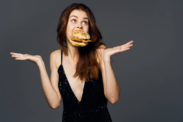 Joven mujer hermosa con hambyrger. Captura de estudio - Foto, imagen