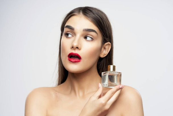 Retrato de jovem mulher bonita com frasco de perfume isolado no fundo branco
 - Foto, Imagem