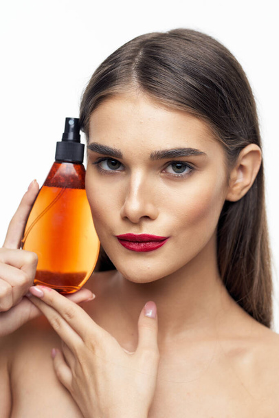 Young beautiful woman with beauty product  in studio  - Foto, Bild