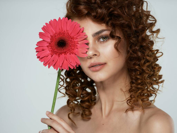 Junge Frau posiert mit Blumen im Atelier - Foto, Bild