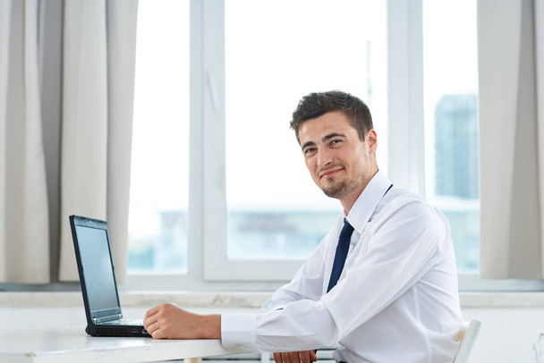 nuori komea liikemies työskentelee kannettavan tietokoneen kanssa - Valokuva, kuva