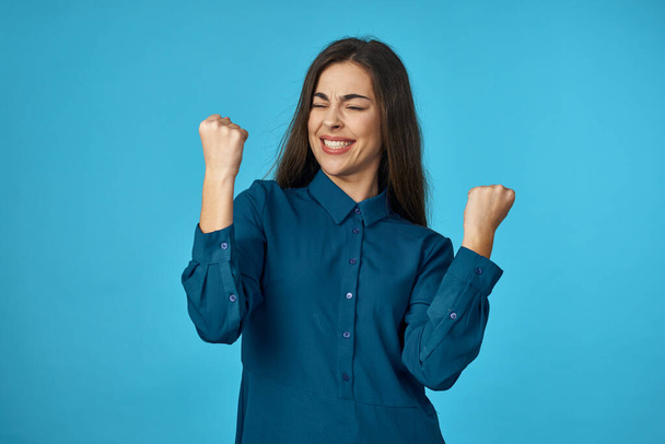 Young woman  celebrating   in studio isolated on blue background  - Photo, Image
