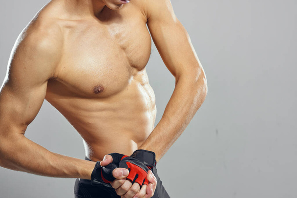 Junger muskulöser Mann mit Handschuhen im Studio - Foto, Bild